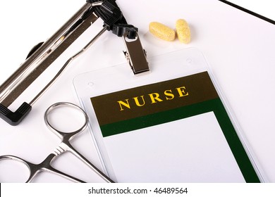 Workplace Of The Nurse About A Badge, Papers For Records, Tablets And A Clip.