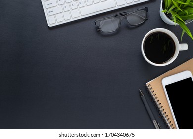 Workplace In Office With Black Desk. Top View From Above Of Keyboard With Notebook And Phone. Space For Modern Creative Work Of Designer. Flat Lay With Blank Copy Space. Business And Finance Concept.