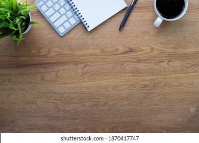Workplace in office with wooden desk. Top view above of keyboard computer with notebook and pen. Space for modern creative work of designer. Flat lay with copy space. Business-finance concept. - Powered by Shutterstock