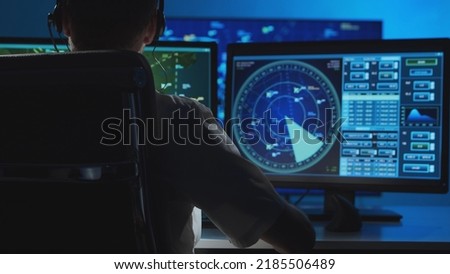Workplace of the professional air traffic controller in the control tower. Caucasian aircraft control officer works using radar, computer navigation and digital maps. Aviation concept.