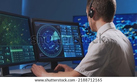 Workplace of the professional air traffic controller in the control tower. Caucasian aircraft control officer works using radar, computer navigation and digital maps. Aviation concept.