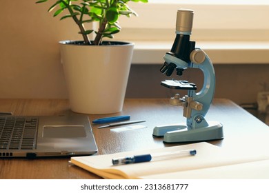 Workplace of a schoolboy with a microscope. Doing homework in chemistry or biology. The process of teaching and scientific research - Powered by Shutterstock - Get 15% off with code: PIKWIZARD15