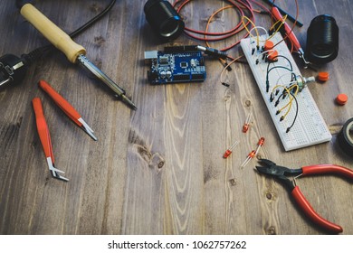 Workplace With Tools: Breadboard, Push Button, Resistors, Tweezers, Nippers, Soldering Iron, Wires, Microcircuit, Lamp Socket. Electronics Repair Service. Concept of  Electronics, Programming. 