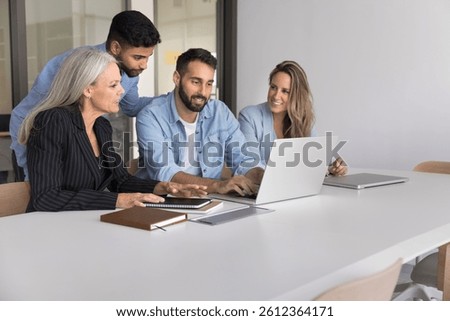 Workplace training and development. Skilled millennial male mentor team leader boss gather multicultural colleagues group on mentoring session teach explain work in online corporate app using notebook