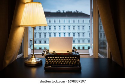 Workplace of a writer, journalist, creator. An old typewriter and a lamp on the table. Retro style. The concept on scientific, historical, literature, education and philosophical topics. 
