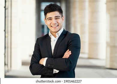 Works As A Manager In A Bank In The City Center. Dark-haired Appearance. Sunlight. Portrait Of A Man In A Black Business Suit And White Shirt Smiling.