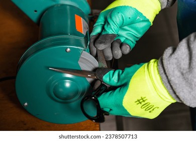 Works on sharpening machines at an industrial enterprise for sharpening scissors and tools - Powered by Shutterstock