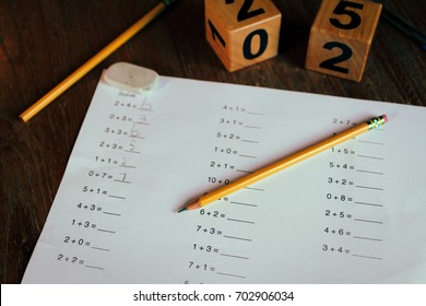 Worksheet For 1st Grade Math Homework With Pencils And Eraser On The Wooden Desk.