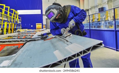 Workshop for assembling metal frames for subway cars, trams and trains. Welders assemble body parts.