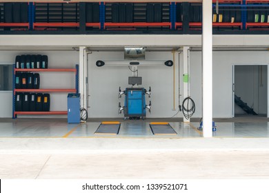 Workshop Bay Of Wheel Alignment With Tyre In A Car Repair Station.
Empty Tire Shop With Wheel And New Tire.