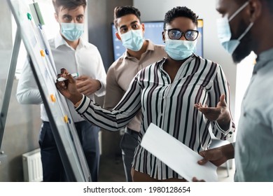 Workshop. Black Female Business Coach In Surgical Medical Face Mask Giving Flipchart Presentation, Speaker Consulting And Training Diverse Multicultural Employees, Mentor Leader Explaining Strategy