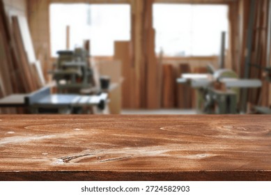 Workshop is filled with various tools and equipment and wooden table on foreground
