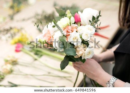 Workshop florist, making bouquets and flower arrangements. Woman collecting a bouquet of flowers. Soft focus