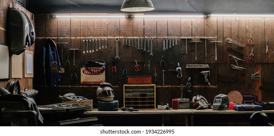 Workshop scene. Old tools hanging on wall in workshop, Tool shelf against a table and wall, vintage garage style - Shutterstock ID 1934226995