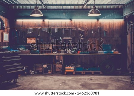 Workshop scene. Old tools hanging on wall in workshop, Tool shelf against a table and wall, vintage garage style