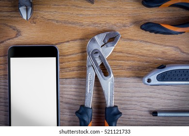 Workshop set  with smart phone. Tools on the table and board.