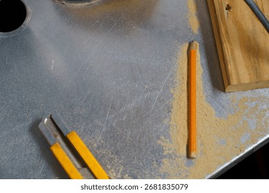 Workshop table with carpenter pencil, utility knife, wood piece and sawdust