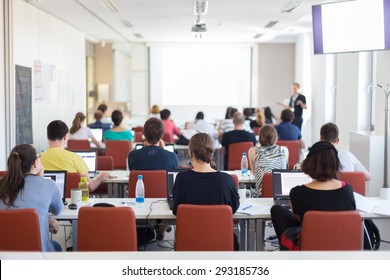 Workshop at university. Rear view of students sitting and listening in lecture hall doing practical tasks on their laptops. - Shutterstock ID 293185736