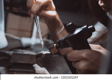 In The Workshop, A Woman Jeweler Is Busy Soldering Jewelry