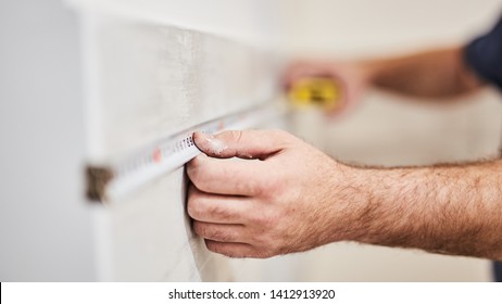 Worksman Using Tape Measure For Home Renovation.