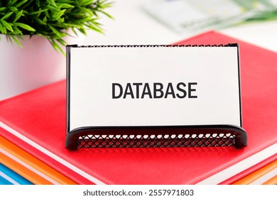 A workspace is arranged with colorful files and a holder displaying a database label. The setting suggests an active organization of documents related to data management or research. - Powered by Shutterstock