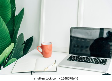 Workspace blank screen computer and equipment and cup of coffee on table and loft wall background.