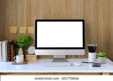 Workspace and blank screen desktop computer.Mockup desktop computer, coffee mug, plant and home office accessories on white desk. - Shutterstock ID 1017758266