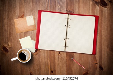 Workspace with coffee cup, instant photos, note paper and notebook on old wooden table