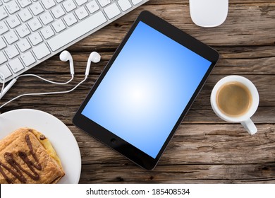 Workspace with coffee cup, tablet pc and note paper on old wooden table