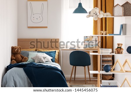 Workspace with desk and chair in elegant teenager's room with blue and orange design