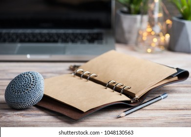 Workspace with empty diary, laptop, lights on wooden background - Shutterstock ID 1048130563