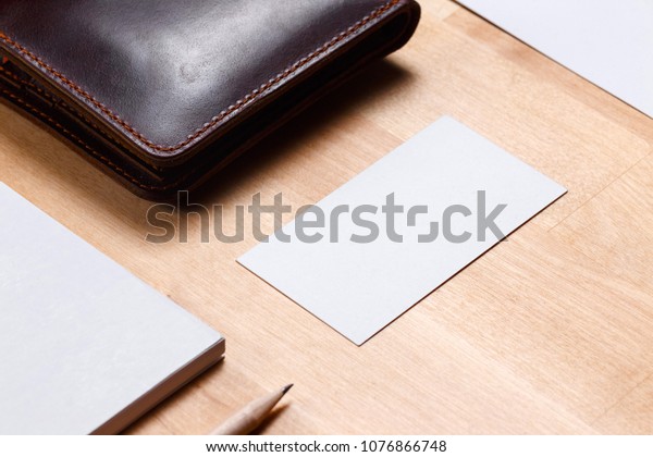 Workspace\
with envelope, wallet, business card, notebook, pencil, badge.\
Office desk wooden background top view mock\
up