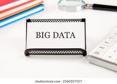 A workspace features a name card displaying big data, alongside study materials and analytical tools reflecting trends in data management and analysis. - Powered by Shutterstock