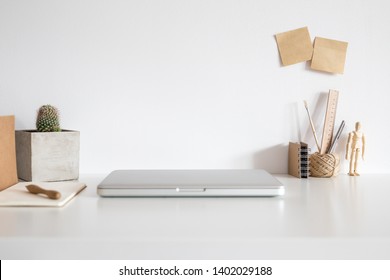 Workspace with laptop closed, wooden supplies and wooden pad under ...