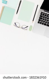 Workspace With Laptop, Glasses And Stationery. White Flatlay With Copy Space.