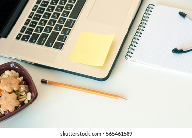 Workspace with laptop notebook sticky notes on white background. Template mock up with copy space for text. Working at home or online concept. Eating healthy snack while working. Healthy Lifestyle.