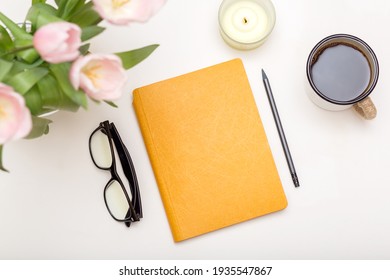 Workspace with modern notebook, stationery, cup of coffee on white table top view. Feminine concept, flat lay desk table