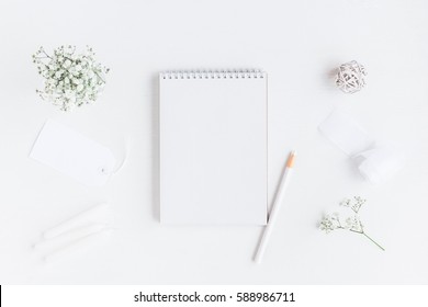 Workspace with notebook, paper blank, gypsophila flowers, pencils. Wedding concept. Flat lay, top view.
