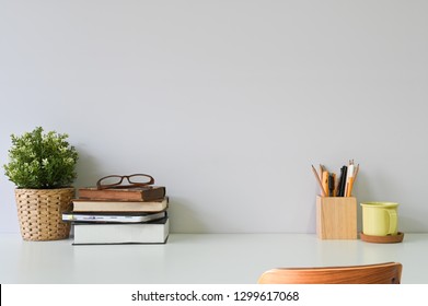 Workspace office table with books, glasses coffee and office supplies on white desk and wood chair. - Powered by Shutterstock