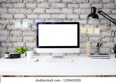 Workspace office table with Pc computer mockup display on white table and brick wall.