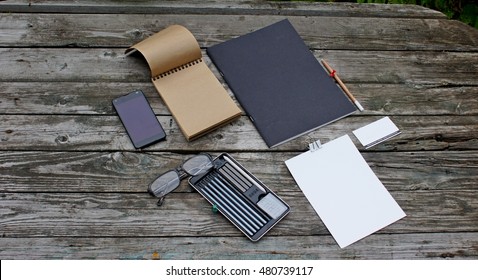 Workspace on a gray old table in the arden with phone, pencil, Notepad, wood,  camera, 