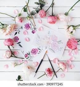 Workspace. Pink And Red Roses Painted With Watercolor, Paintbrush And Roses On White Wooden Background. Overhead View. Flat Lay, Top View