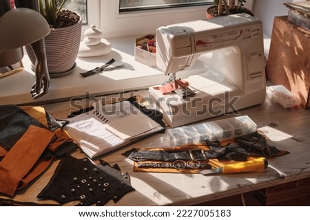 Workspace of Stylist. The working surface of the desktop by the window. Workplace of a designer of fashionable belts and bags. Hobby concept. Making accessories by handmade. Tailor's corner
