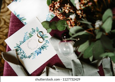 Workspace. Wedding invitations, craft envelopes, green and blue leaves on white background. The view from the top. Flat layout, top view