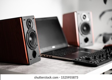 Workstation with speakers and computer in studio. Desktop in home office. Selective focus on the speaker.