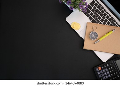 Worktable black leather workspace with office supplies and copy space with laptop and notebook. View from above.