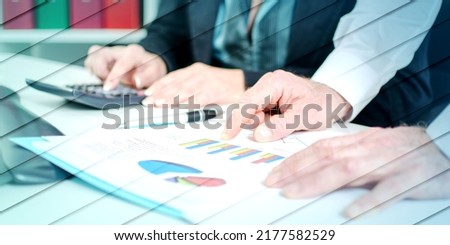 Workteam in office analyzing graphs and using a calculator, geometric pattern