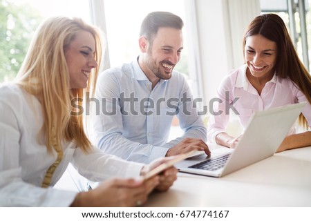 Workteam in office working together on laptop