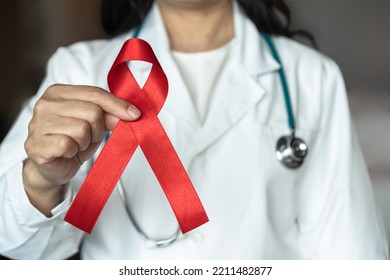 World Aids Day And National HIV AIDS And Ageing Awareness Month With Red Ribbon On Medical Or Surgical Doctor's Hand 