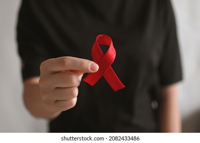 World AIDS And Hiv Day. World Remembrance Day Of AIDS Victims. Woman In Black T-shirt Holds A Red Ribbon. Blood Transfusion And Donation. Hemophilia Day. World Cancer Day 